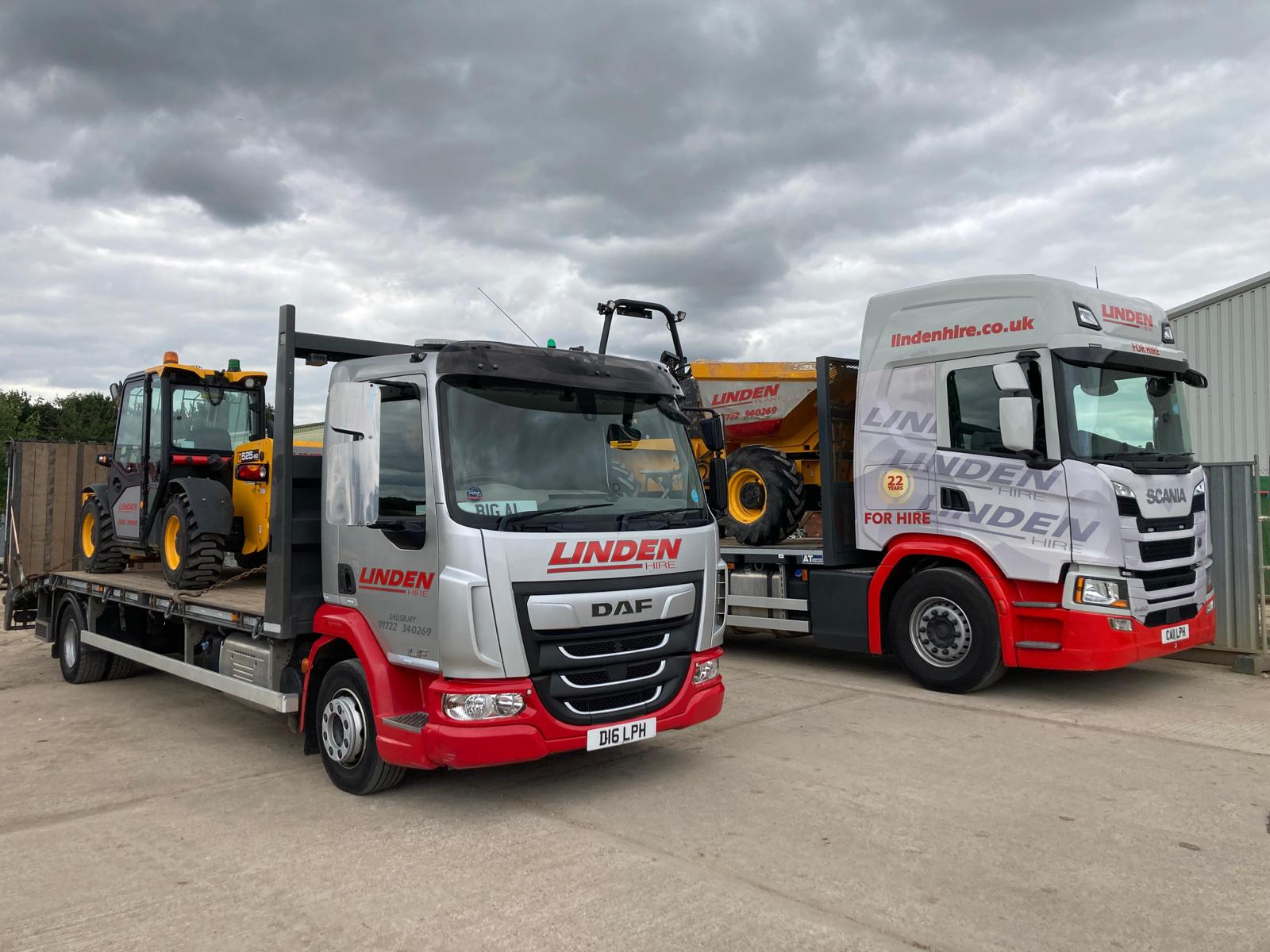 Image of lorries loaded with plant hire machinery.